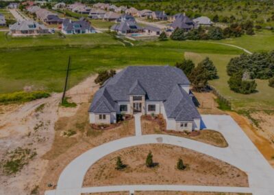 An aerial view of a country home surrounded by lush green fields and trees.