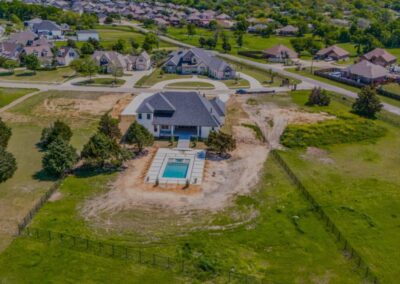 Overhead shot of a residence in a suburban area with houses and roads.