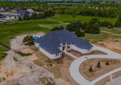 Overhead shot of a residence in a suburban area with houses and roads.