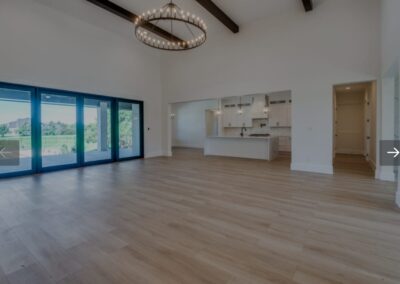 Spacious living room with hardwood floors and elegant chandelier.