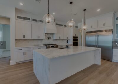 Large open living area featuring hardwood floors and a chandelier.