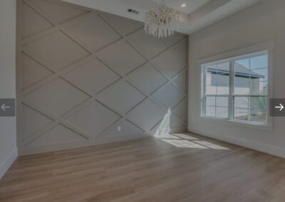 Roomy living space with hardwood flooring and a stunning chandelier.